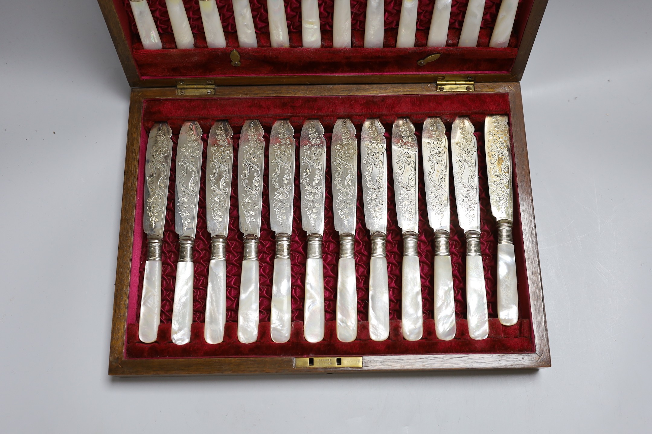 Twelve pairs of silver plated fish knives and forks with mother of pearl handles, in wooden canteen